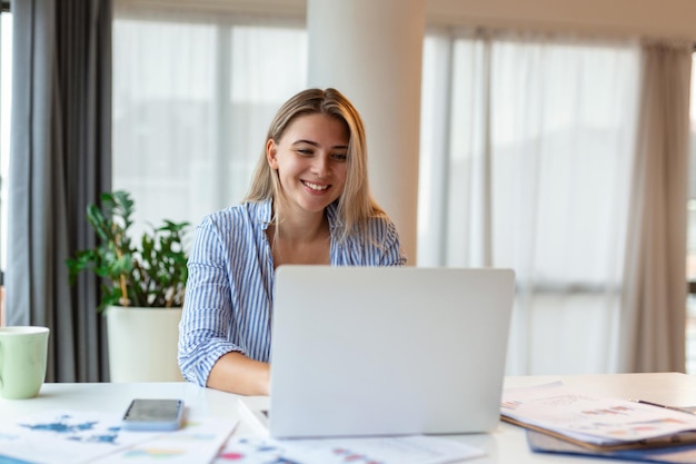 Mooie vrouw freelancer die informatie opmerkt voor het plannen van een project op afstand via een laptop computer vrouw die e-mail leest op een modern laptopapparaat