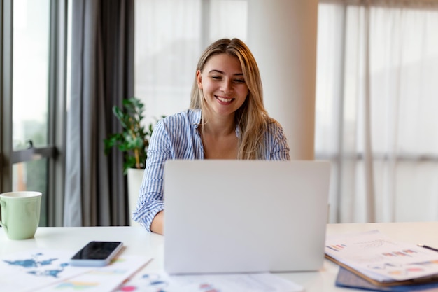 Mooie vrouw freelancer die informatie opmerkt voor het plannen van een project op afstand via een laptop computer vrouw die e-mail leest op een modern laptopapparaat