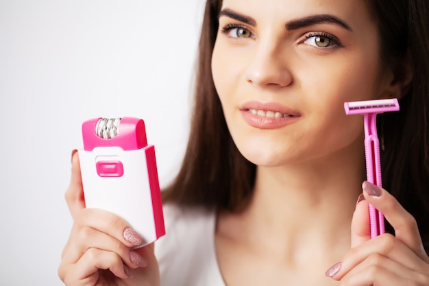 Mooie vrouw gebruikt een epilator om haar te verwijderen