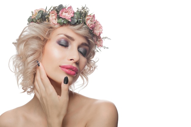 Mooie vrouw geïsoleerd op wit portret Mooi model met make-up blond krullend haar en bloemen