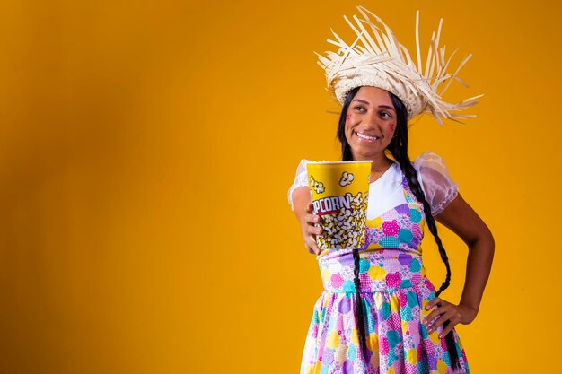 Mooie vrouw gekleed in juni feestoutfit die popcorn eet