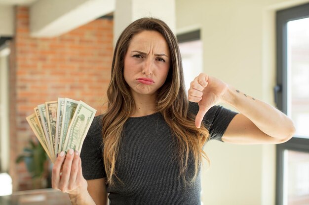 Foto mooie vrouw gevoel crossshowing duim omlaag dollar bankbiljetten concept