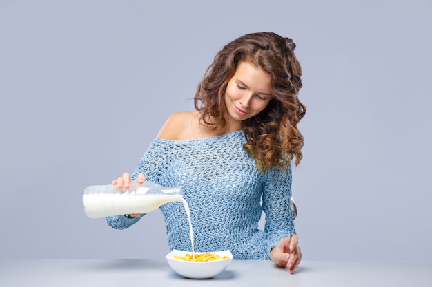 Mooie vrouw giet melk in glas