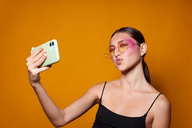 Mooie vrouw glimlach helder roze make-up emoties cosmetica smartphone selfie geïsoleerde achtergrond ongewijzigd
