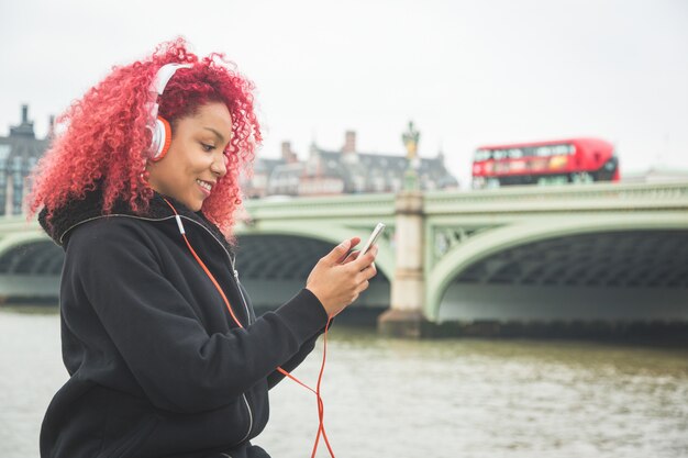 Mooie vrouw het luisteren muziek in Londen