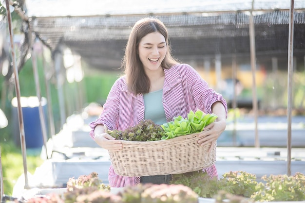 Mooie vrouw houdt verse groenten uit de kastuin op het dak en plant biologische boerderij