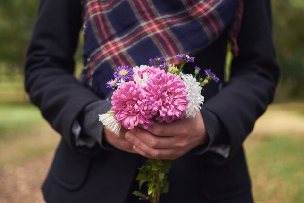 Mooie vrouw houdt wilde bloemen in haar handen