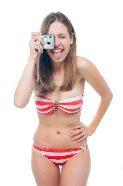 Mooie vrouw in bikini die foto op de camera maakt die op witte achtergrond wordt geïsoleerd