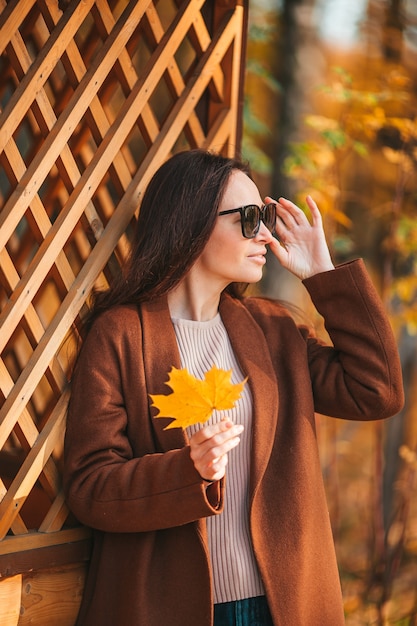 Foto mooie vrouw in de herfstpark onder dalingsgebladerte