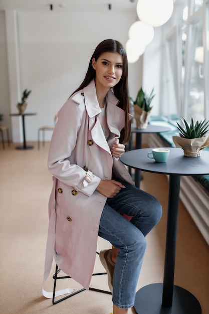 Mooie vrouw in een coffeeshop met een kopje koffie