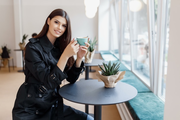 Mooie vrouw in een coffeeshop met een kopje koffie