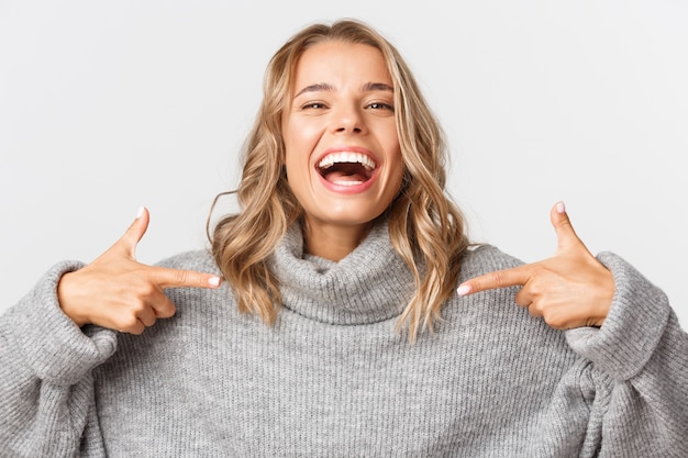 Mooie vrouw in een grijze trui poseren