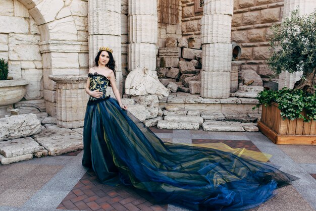 Mooie vrouw in een luxe blauwe jurk met een lange trein