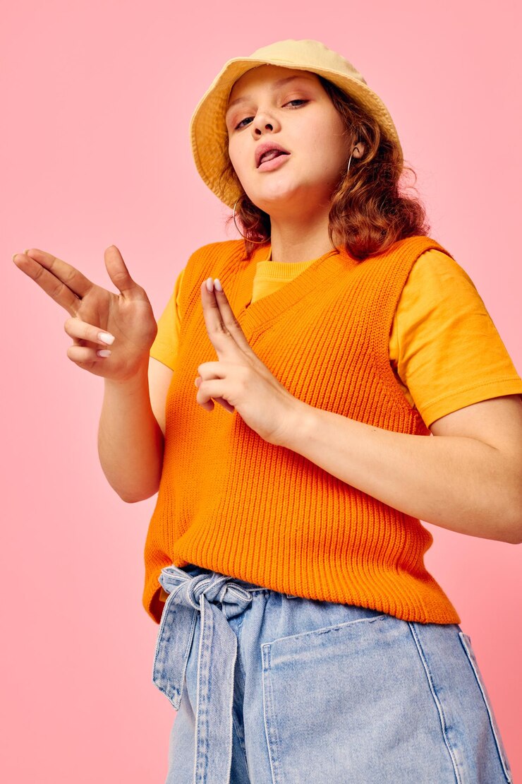 Foto mooie vrouw in een oranje trui in gele hoed handgebaar geïsoleerde achtergronden ongewijzigd