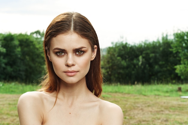 Mooie vrouw in een veld buiten blote schouders heldere huid bijgesneden weergave