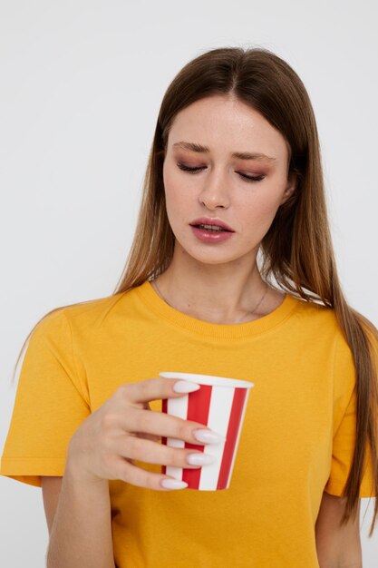 Mooie vrouw in geel t-shirtglas met drankje