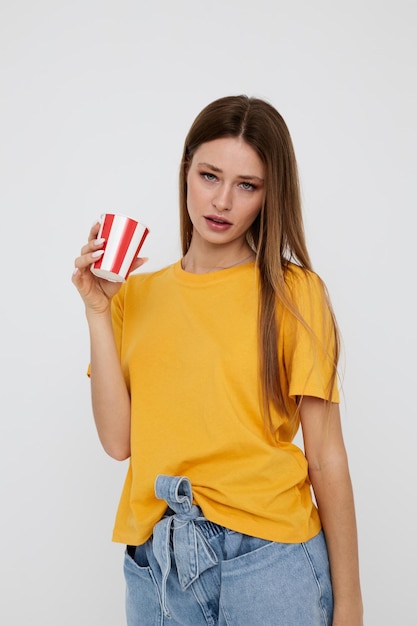 Mooie vrouw in geel t-shirtglas met drankje