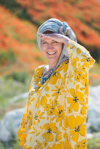 Mooie vrouw in gele jurk op het weiland gebied van zeer warm weer.