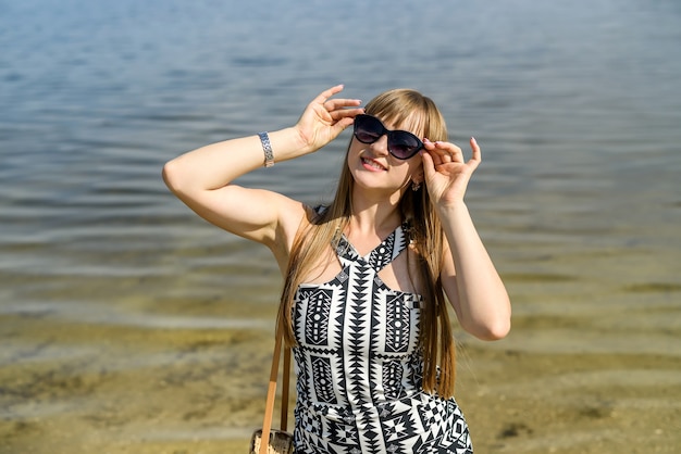 Mooie vrouw in jurk in de buurt van meer, zomertijd