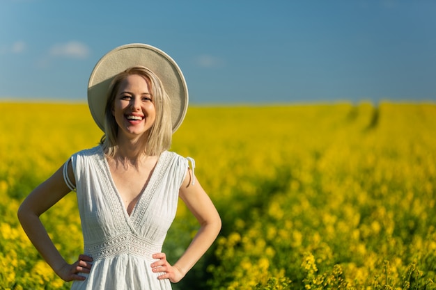 Mooie vrouw in jurk in koolzaad veld