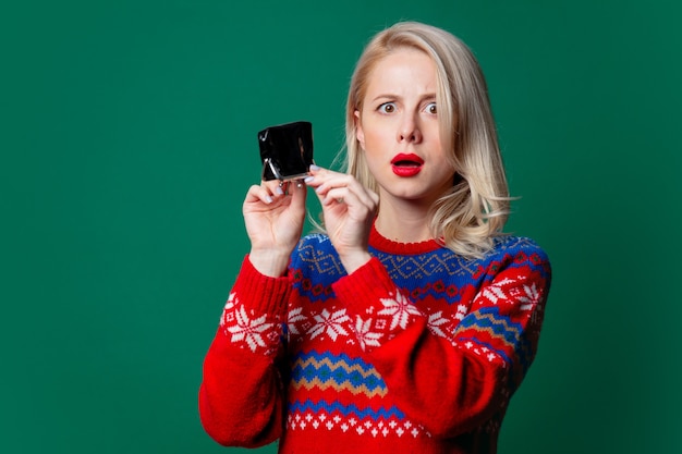 Mooie vrouw in Kerstmissweater met lege beurs