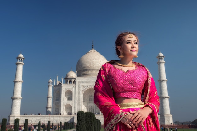 Mooie vrouw in klederdrachtkostuum, Aziatische vrouw die typische saree / sari-kleding identiteitscultuur van India draagt. Taj Mahal Scenic De ochtendweergave van het Taj Mahal-monument in Agra, India.