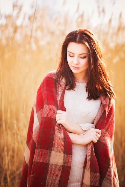 Mooie vrouw in plaid op een veld