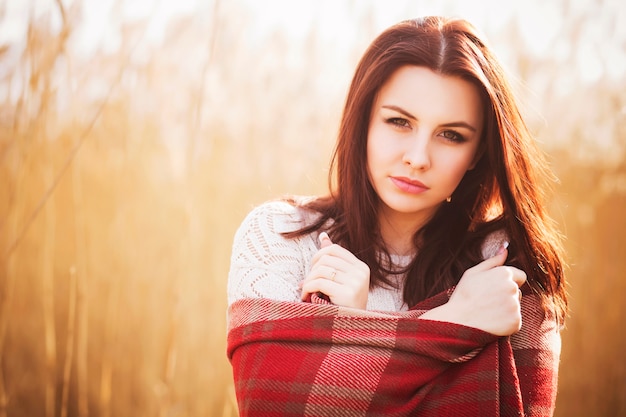 Mooie vrouw in plaid op een veld