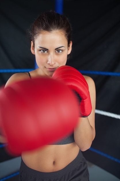 Mooie vrouw in rode bokshandschoenen in de ring