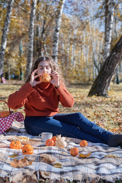 Mooie vrouw in rode trui op een picknick in een herfstbos