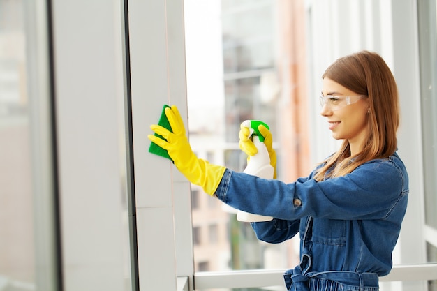 Mooie vrouw in uniform met leveringen schoonmaken in kantoor.