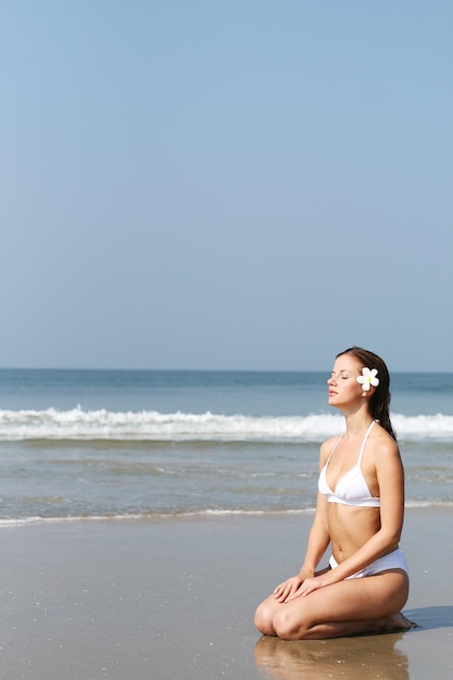 Mooie vrouw in wit zwempak bij het strand