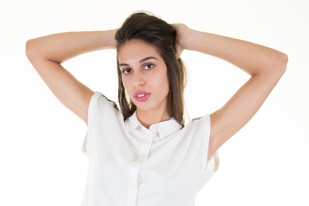 Mooie vrouw in witte blouse met hand achter haar hoofd