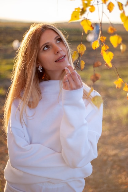 Mooie vrouw in witte casual warme kleding in de gezellige herfst