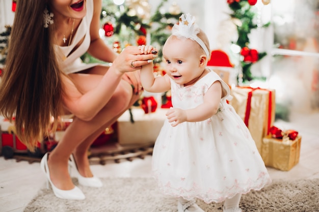 Mooie vrouw in witte jurk met mooie kleine baby meisje