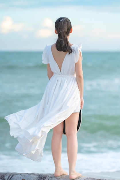 Mooie vrouw in witte jurk op het strand