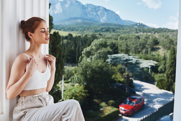 Mooie vrouw in witte t-shirt op het balkon in de bergen