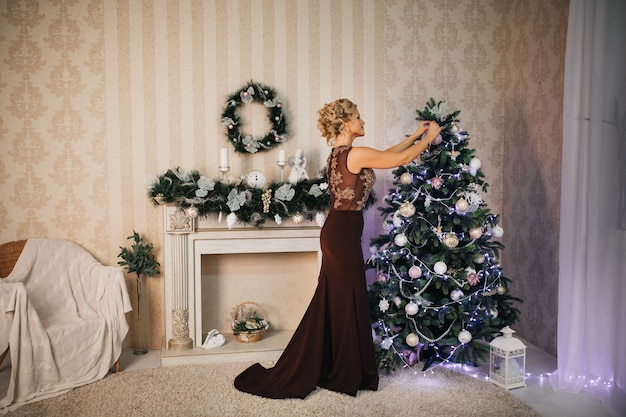 mooie vrouw kleedt een kerstboom