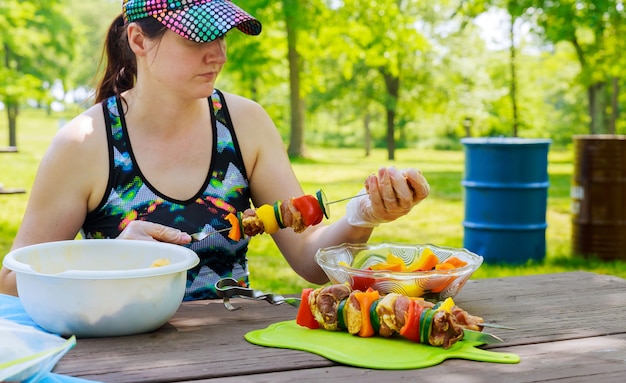 Foto mooie vrouw kleedt zich aan spiesjes van shish kebab