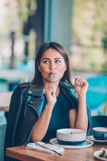 Mooie vrouw koffie drinken in herfst park onder fall gebladerte