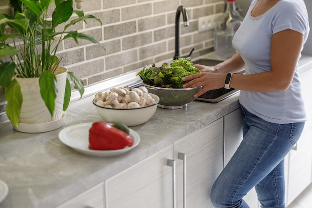 Mooie vrouw kookt heerlijke gerechten in haar eigen keuken