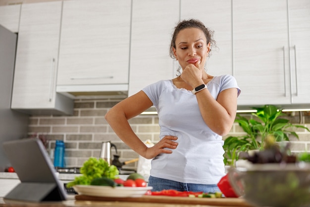 Mooie vrouw kookt heerlijke gerechten in haar eigen keuken