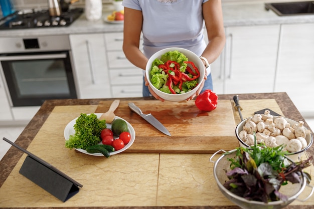 Mooie vrouw kookt heerlijke gerechten in haar eigen keuken