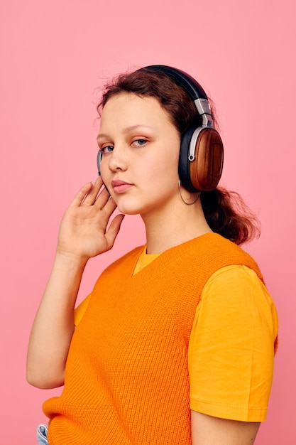 Mooie vrouw koptelefoon muziek mode poseren roze achtergrond ongewijzigd