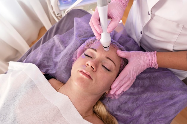 Mooie vrouw krijgt gezicht vacuüm procedure voor gezonde huid in de spa salon