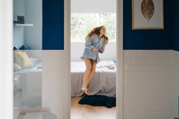 mooie vrouw loopt in haar slaapkamer