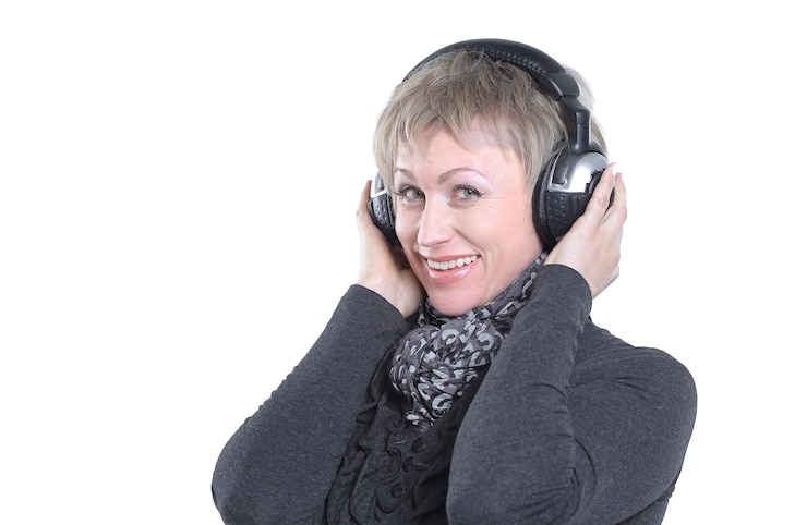 Foto mooie vrouw luisteren naar muziek met koptelefoon geïsoleerd op een witte achtergrond