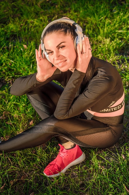 Mooie vrouw luisteren naar muziek via oortelefoon./Pretty jonge vrouw met koptelefoon buiten genieten van muziek.