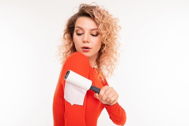 Mooie vrouw maakt kleding schoon met een kleverige roller