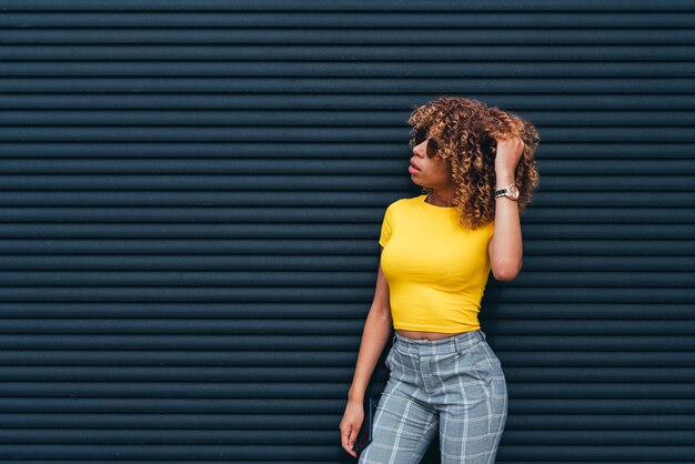 Mooie vrouw met afro het stellen in de straat